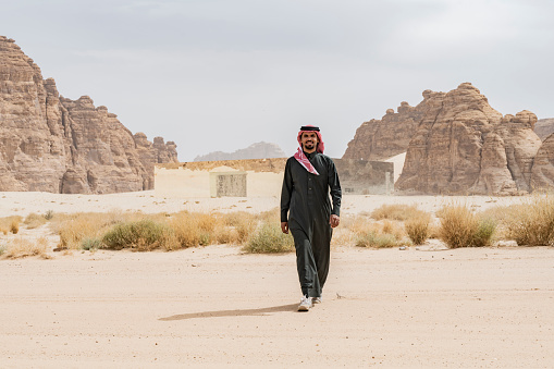 Al Ula, Saudi Arabia - March 6, 2022: Maraya Concert Hall and cultural centre. A local Saudi man walks away into the desert.