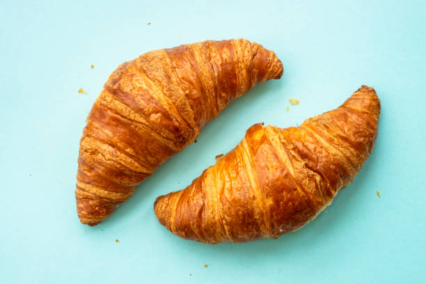 istock Croissant at blue background flat lay. 1990221917