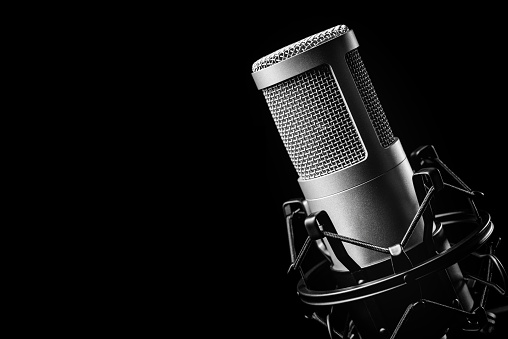 Studio microphone on the black background. Concept for podcast or sound recording. Copy space.