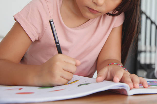 istock Unrecognizable Young Little Girl Doing Homework at Home 1990244255