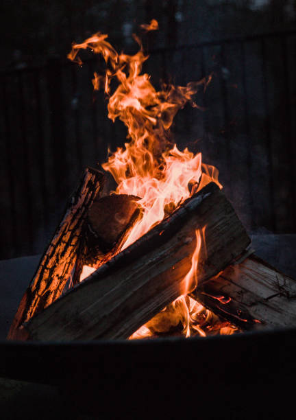 blick hinunter auf brennendes lagerfeuer in feuerstelle (winteraktivität im freien) - fire pit fire camping burning stock-fotos und bilder