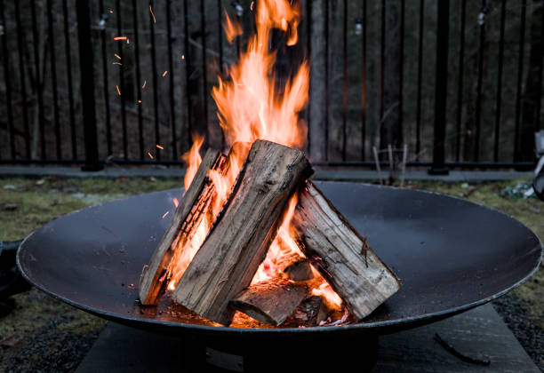 blick hinunter auf brennendes lagerfeuer in feuerstelle (winteraktivität im freien) - fire pit fire camping burning stock-fotos und bilder