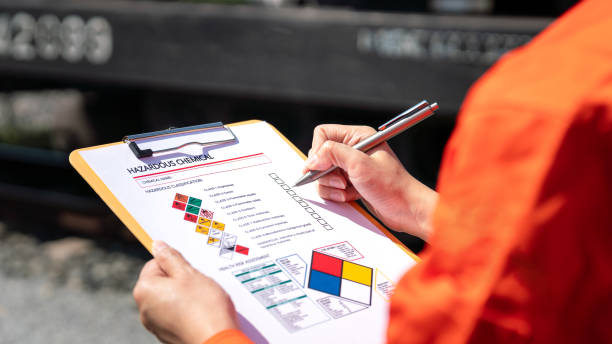 Checking on chemical hazardous material checklist Action of an engineer is checking on chemical hazardous material checklist form with background of train freight tanker for crude oil or chemical cargo. Industrial safety working scene. unsafe workplace stock pictures, royalty-free photos & images