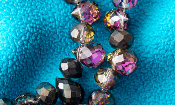 Precious stones on beads on blue fabric. Background.