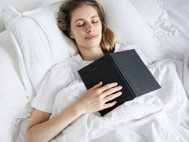 istock A young beautiful girl fell asleep reading a book before sleeping 1990286872