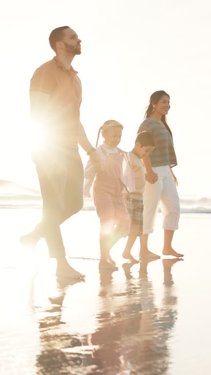 Beach, walking and family holding hands, happiness or ocean with weekend break or vacation. Parents, mother or father with summer or seaside with holiday, lens flare or bonding together with children