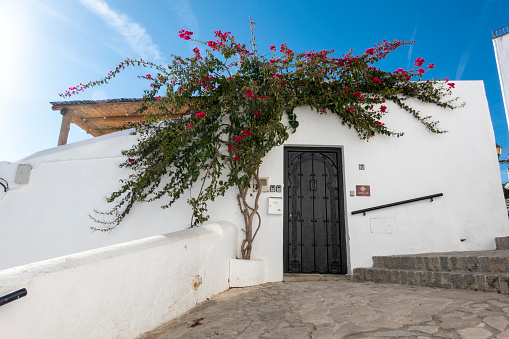 Vejer de la Frontera, Cadiz, Spain - February 04, 2024: White facade of a traditional Spanish village house with old wooden door carved in Arabic style
