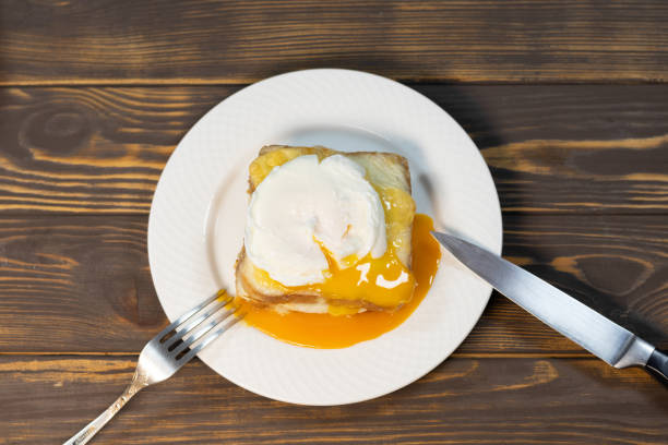 Croque madame, grilled sandwiches with sliced ham, melted cheese, dijon mustard and poached egg on  bechamel sauce.
