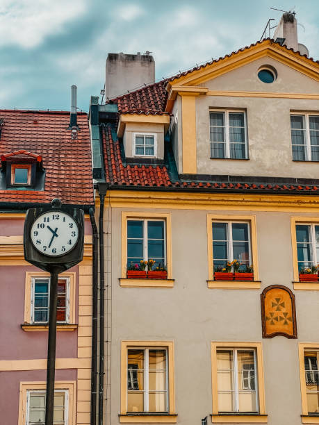 istock Ancient city clock and a beautiful house in Prague 1990339178