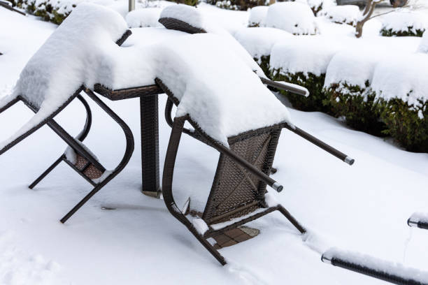 istock Plastic chairs and a garden table covered with a thick layer of snow. 1990350887