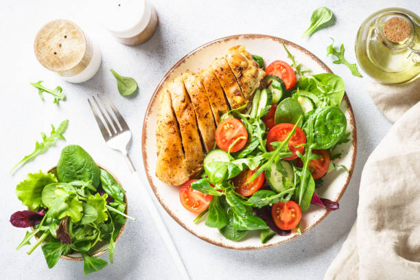 istock Green salad with chicken fillet on white. 1990352462