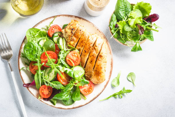 istock Green salad with chicken fillet on white. 1990352466