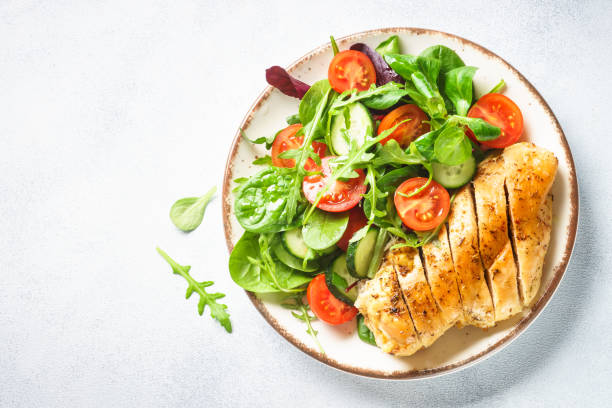 Green salad with chicken fillet on white.