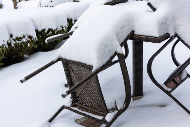 istock Plastic chairs and a garden table covered with a thick layer of snow. 1990354613