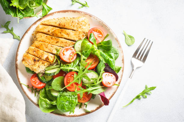 istock Green salad with chicken fillet on white. 1990354632