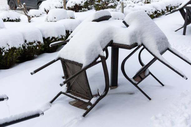 istock Plastic chairs and a garden table covered with a thick layer of snow. 1990355171