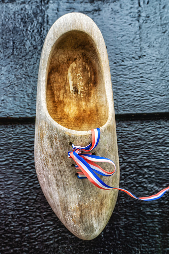 Traditional old wooden shoe or clog hanging as decoration on front door, The Netherlands