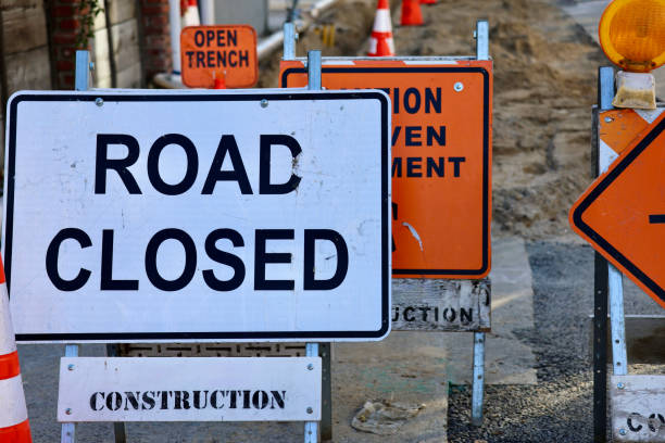 istock Road crew has placed warning signs around the open trench 1990371216