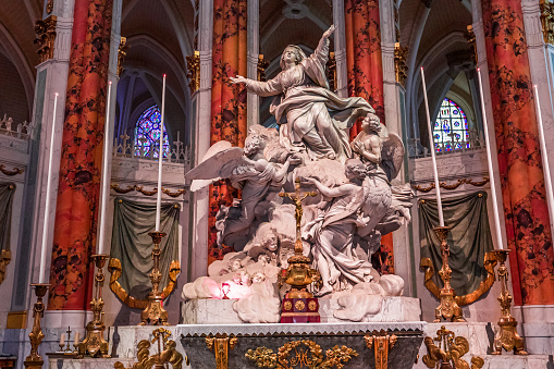 Chartres, france, march 27, 2022 : altar and choir of Cathedral of Our Lady of Chartres : The high altar dates from the end of the 18th century. This marble group made in 1772 by Charles-Antoine Bridan represents the Assumption of Mary