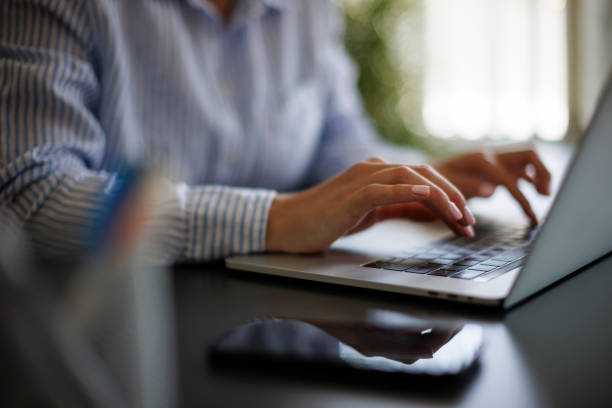 istock Closeup of woman using laptop computer 1990386449