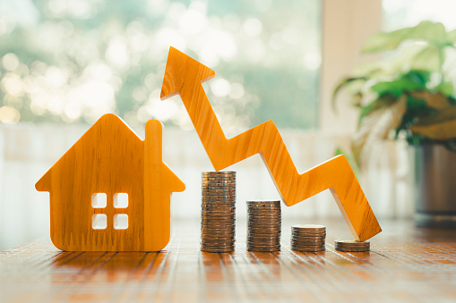 Wood house and row of coin money on wood table and , selective focus, Planning to buy property. Choose what's the best. A symbol for construction ,ecology, loan concepts