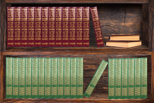 Books on the bookshelves in the library. Dark wood bookcase