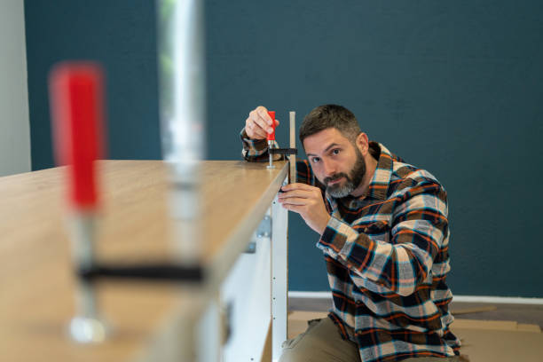 istock Caucasian handyman adjusting clamps, while assembling kitchen counter, at the new apartment 1990413131