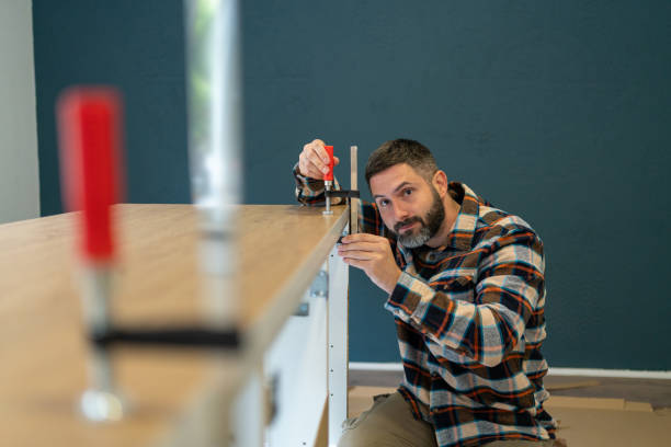 istock Caucasian man adjusting clamps, while assembling kitchen counter, at the new apartment 1990413133