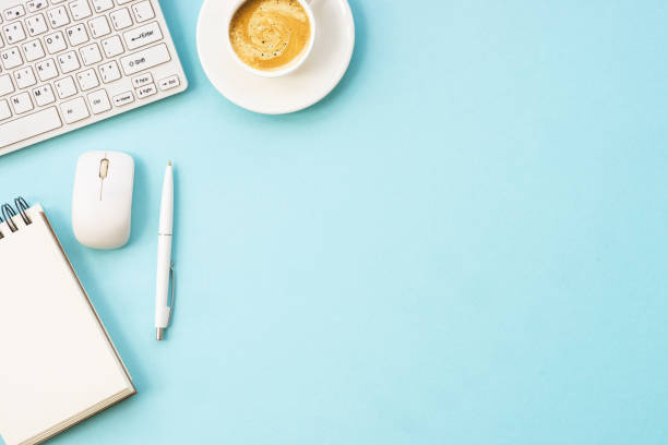 Office table desk with laptop, notepad, pen and cup of coffee.