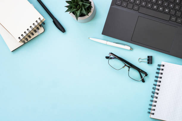 istock Office table desk with laptop, headphones, notepad and pen. 1990420752