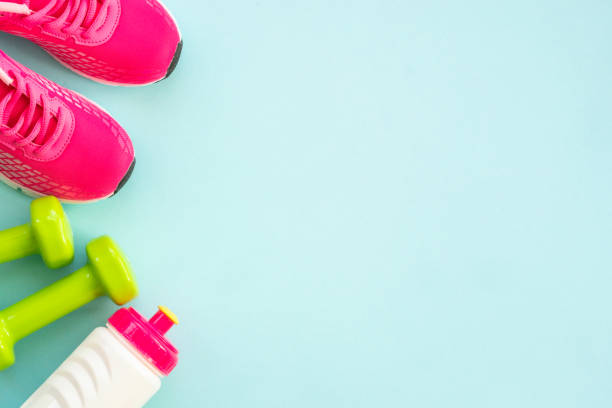 istock Dumbbells, sneakers, measuring tape, water bottle and notepad on blue. 1990422928