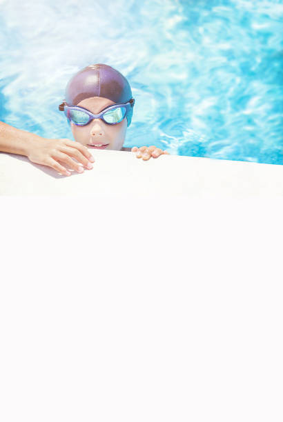 Child in cap, sport goggles ready to learns professional swimming. Copy space.