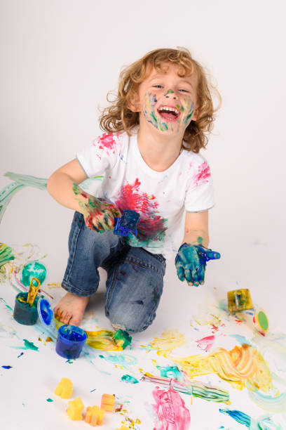 istock Positive boy covered with colorful paints 1990446585