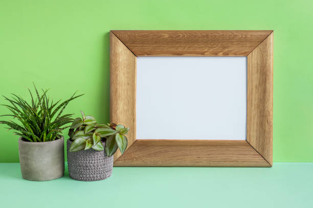 istock Wooden mock up photo frame and home plants 1990447099