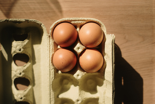 An egg carton with four eggs