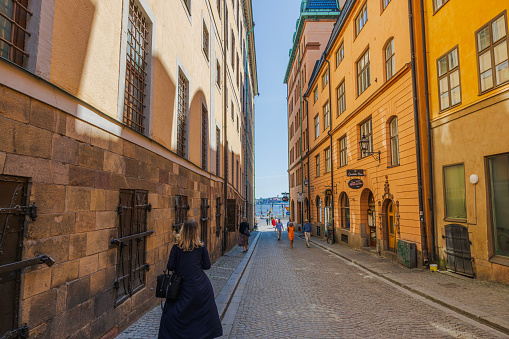 Sweden. Stockholm. 06.06.2023. View of a narrow cobblestone tourist alley in Gamlastan, Stockholm, leading to the river waterfront.