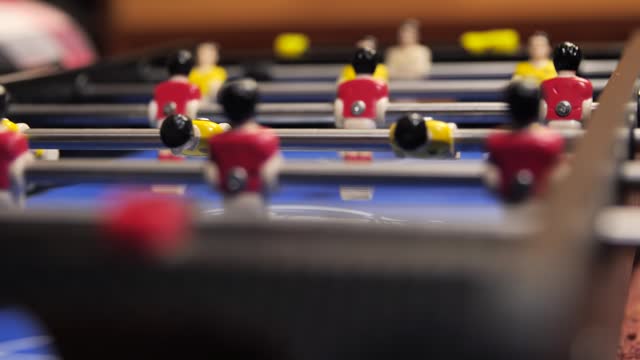 Close-up of foosball players figurines rotate during the game.