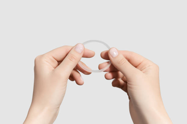 female hands holding hormonal contraceptive ring isolated on grey background female hands holding hormonal contraceptive ring isolated on grey background diaphragm contraceptive stock pictures, royalty-free photos & images