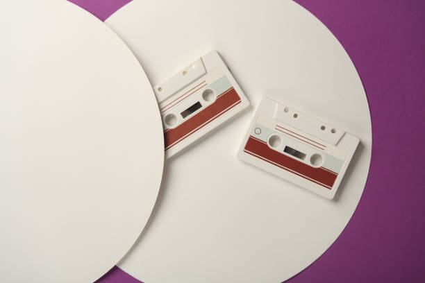 Retro 80s audio cassettes on purple background with white circles. Top view