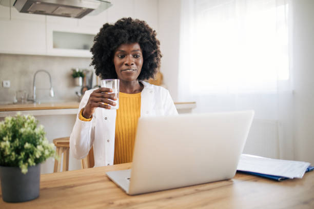istock A young African-American female doctor works on the computer while sitting at the kitchen table 1990525099