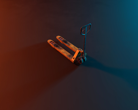 Yellow hand forklift in blue and red coloured light. Studio shot. High angle view.