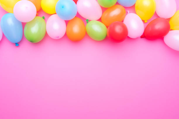 istock Party balloons border on pink background. Copy space 1990537485