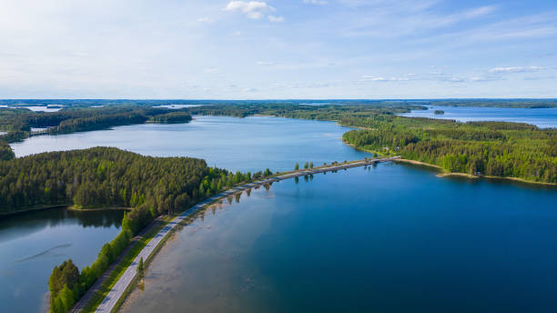 Typical finnish landscape with blue lakes, forest and a scenic road Typical finnish landscape with blue lakes, forest and a scenic road etela savo finland stock pictures, royalty-free photos & images