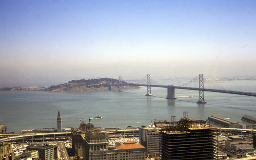 High angle view of San Francisco Ferry Building, San Francisco-Oakland Bay Bridge, Yerba Buena Island and surrounds in light morning fog taken in 1967.