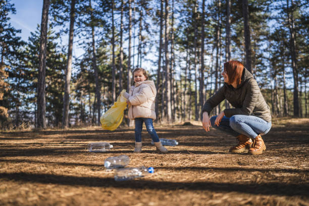 istock mother and daughter collect plastic bottle garbage waste in forest 1990551017