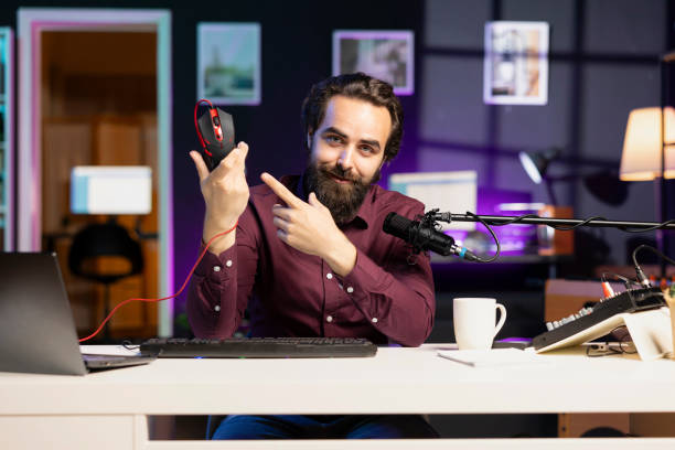 istock Happy content creator showing viewers gaming mouse, endorsing it 1990553759
