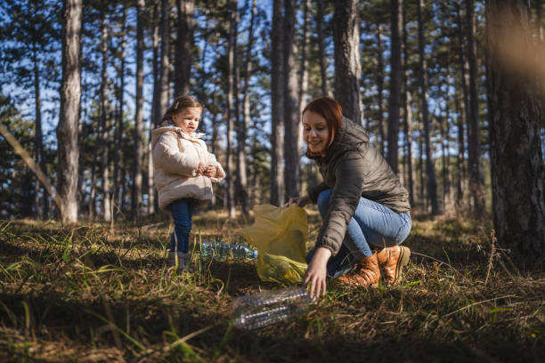 istock mother and daughter collect plastic bottle garbage waste in forest 1990553779
