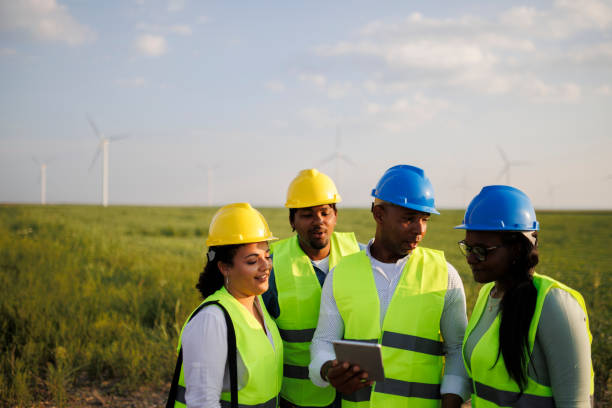 istock Engineers wearing uniform ,helmet hold document inspection work in wind turbine farms rotation to generate electricity energy. 1990586997