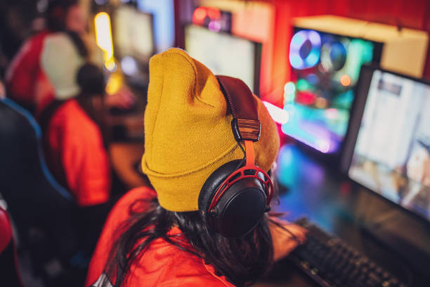 Multiracial group of people, professional cybersport gamers playing video games on esports competition on desktop computers together in gaming club.