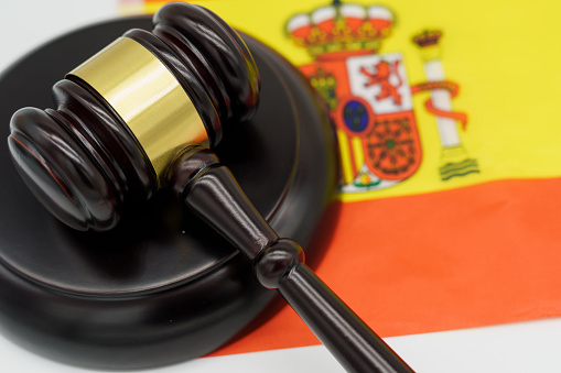 Justice in Spain. A judges gavel rests on the vibrant Spanish flag, symbolizing the countrys legal system